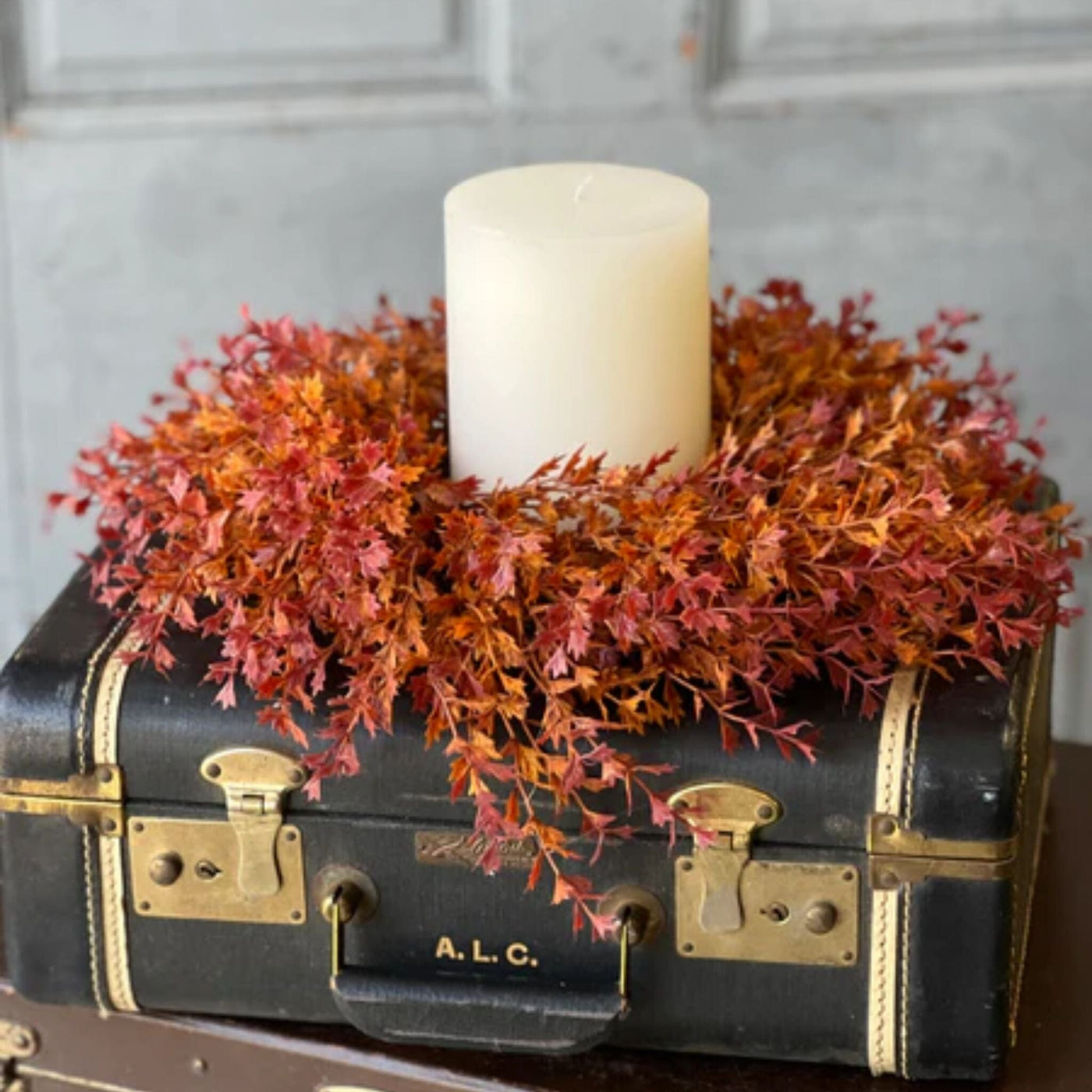 Tiny orange and red leaves on fluffy stems attached to a vine wreath.