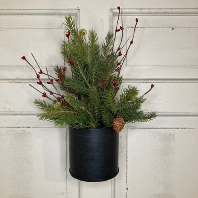Evergreen branches and red berry sprigs in a hanging Iron container 